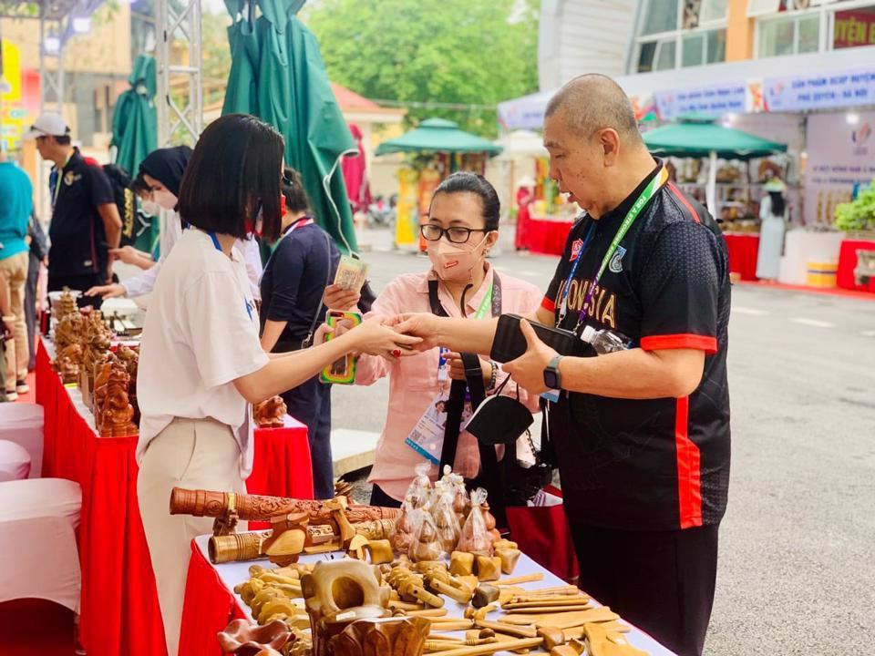 Du kh&aacute;ch mua qu&agrave; lưu niệm tại gian h&agrave;ng OCOP trong khu&ocirc;n vi&ecirc;n Trung t&acirc;m VH-TT&amp;TT huyện Thanh Tr&igrave;.