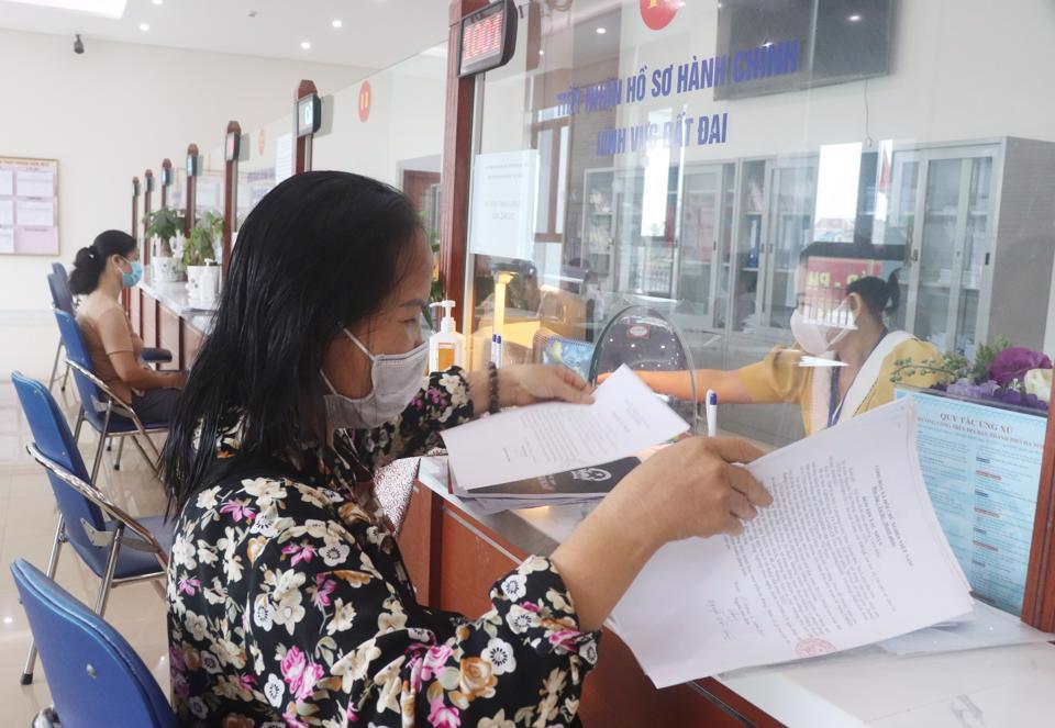 Người d&acirc;n thực hiện thủ tục h&agrave;nh ch&iacute;nh tại bộ phận Một cửa tại quận Bắc Từ Li&ecirc;m. Ảnh: Thảo Trần