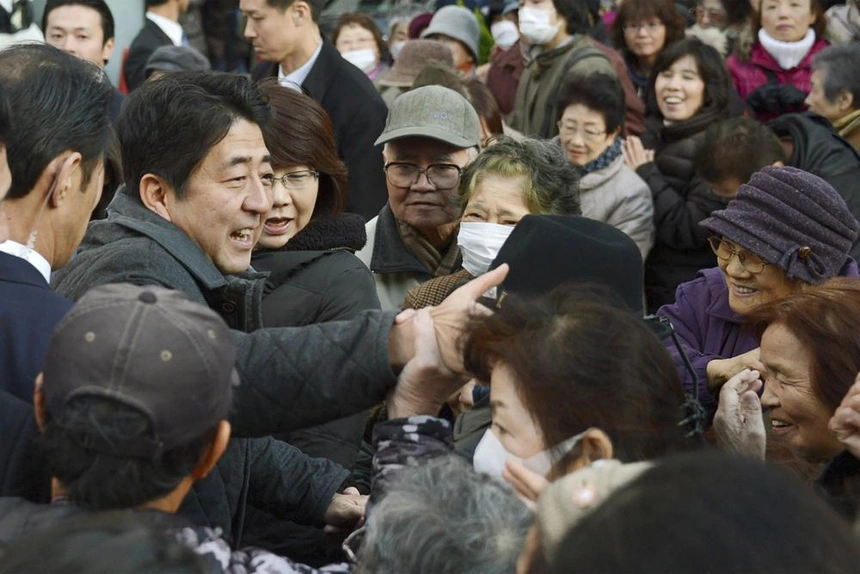 Ông Shinzo Abe (trái) bắt tay với cử tri hồi tháng 12/2012. Ảnh: Kyodo News.