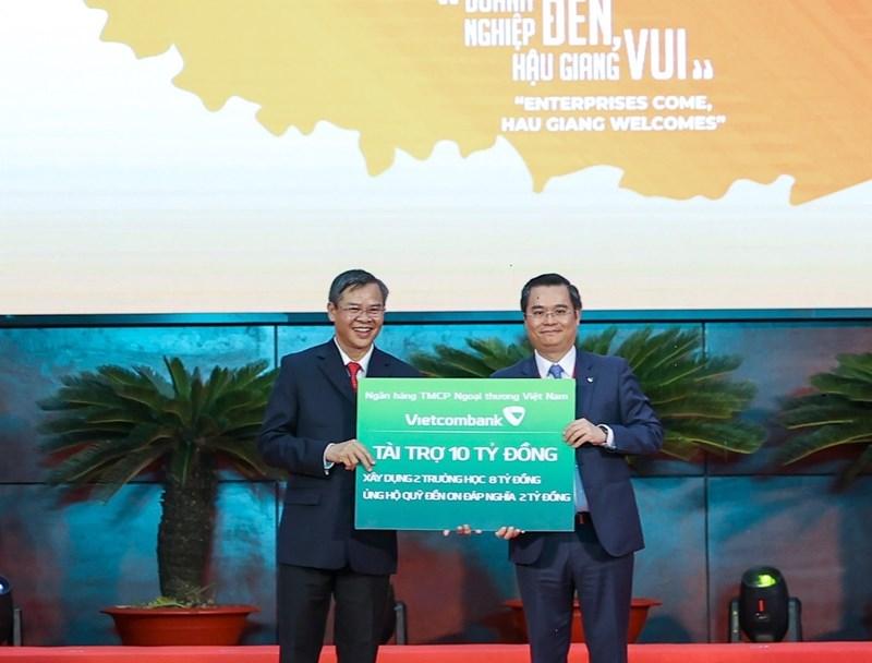 Đại diện Vietcombank, ông Nguyễn Thanh Tùng - Phó Tổng Giám đốc phụ trách Ban điều hành Vietcombank (bên trái) trao biển tài trợ 10 tỷ đồng công tác an sinh xã hội tỉnh Hậu Giang