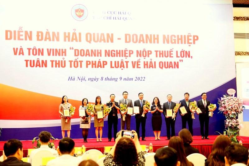 Tổng cục trưởng Tổng cục Hải quan Nguyễn Văn Cẩn và Tổng biên tập Tạp chí Hải quan Vũ Thị Ánh Hồng trao Kỷ niệm chương và hoa cho đại diện 9 DN được tôn vinh.