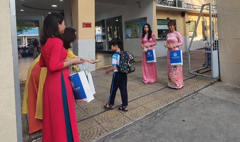 Giáo viên Trường tiểu học Trần Hưng Đạo tặng quà cho học sinh tại cổng trường.