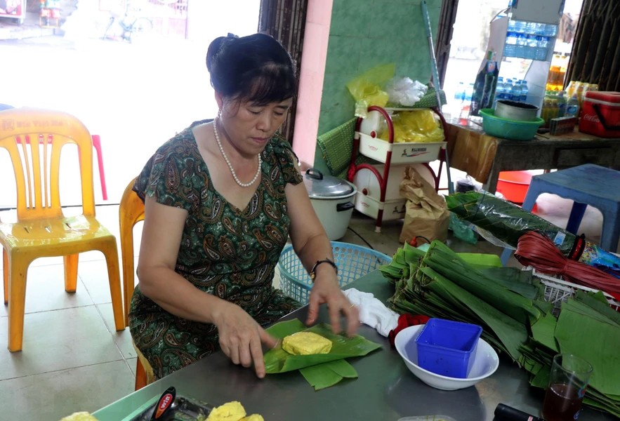 Công đoạn gói bánh phu thê. Ảnh TTXVN