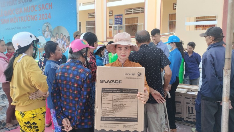 Người dân xã Khánh An, huyện U Minh phấn khởi nhận bình lọc nước do Tổ chức UNICEF hỗ trợ. (Ảnh: TG)