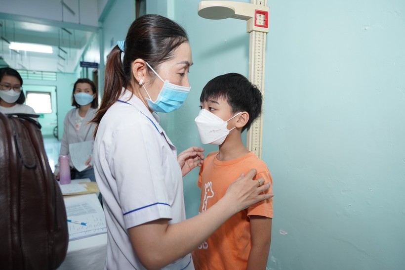 Bác sĩ đo chiều cao cho trẻ khi đến Bệnh viện Nguyễn Tri Phương tầm soát. (Ảnh: BVCC)