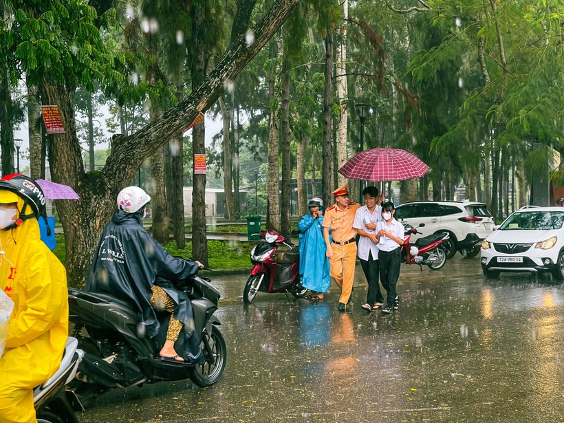 Sáng 28/6, Bà Rịa-Vũng Tàu có mưa lớn, lực lượng cảnh sát giao thông đã hỗ trợ các thí sinh vào điểm thi. Ảnh: KC.