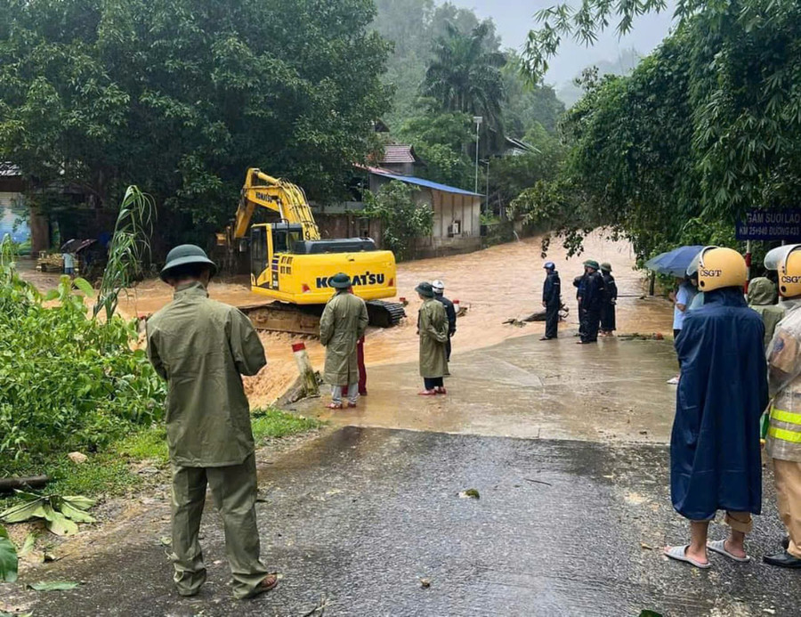 Chính quyền địa phương huy động máy móc khơi thông cống rãnh, giúp người dân vùng lũ.