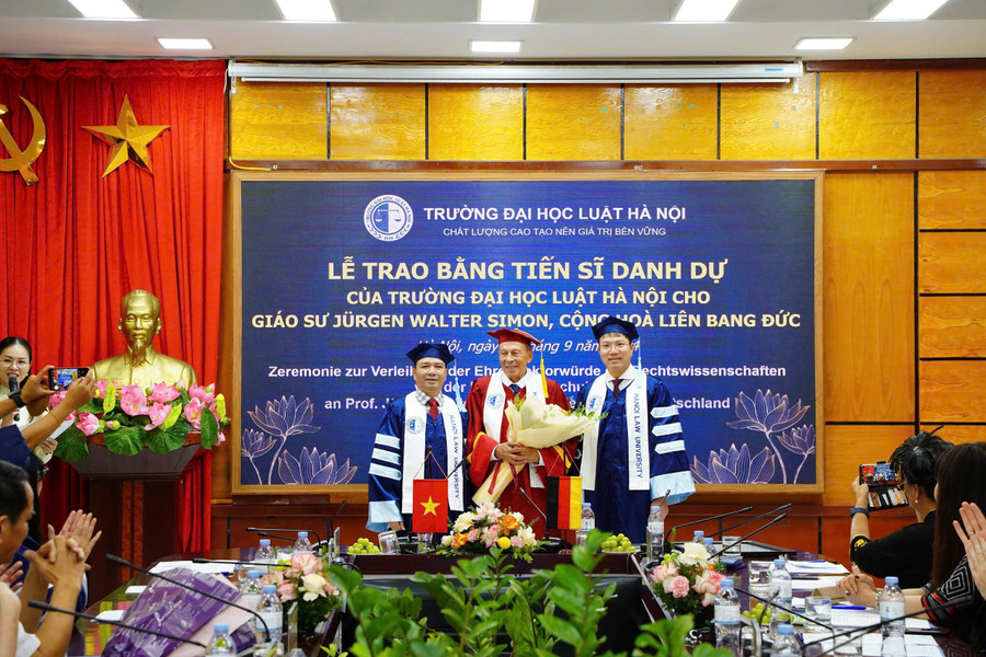 TS. Đoàn Trung Kiên (bên phải) - Hiệu trưởng Trường ĐH Luật Hà Nội trao bằng tiến sĩ danh dự cho GS.TS Jürgen Walter Simon.