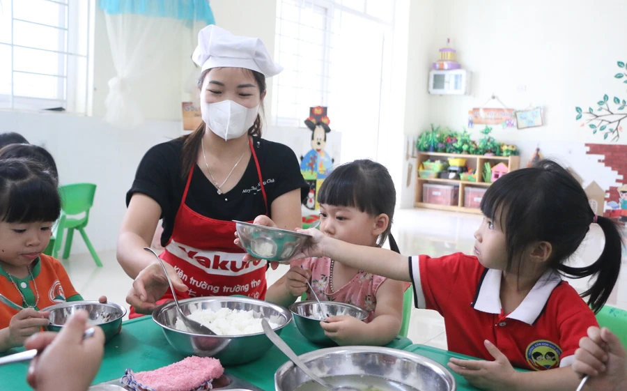 Nhân viên nuôi dưỡng tại Trường Mầm non Hoa Sơn (Ứng Hòa, Hà Nội) cho trẻ ăn trưa. Ảnh: Khôi Nguyên