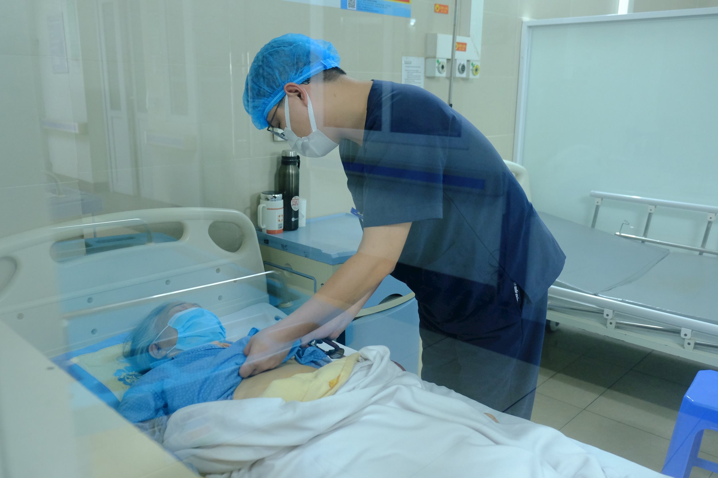 Bác sĩ thăm khám cho bệnh nhân mắc COVID-19.