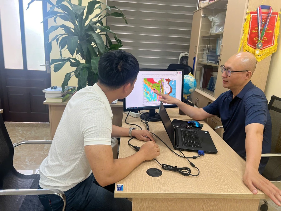 TS Cao Đình Trọng (bên phải) trao đổi về kết quả phân tích, tính toán động đất kích thích do hồ chứa thủy điện.
