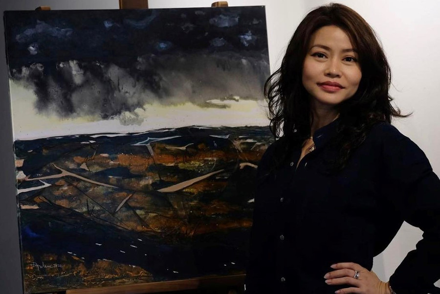 Họa sĩ Đoàn Quỳnh Như bên một tác phẩm của mình tại triển lãm 'Khiêu vũ tới trập trùng' diễn ra vào năm 2022.