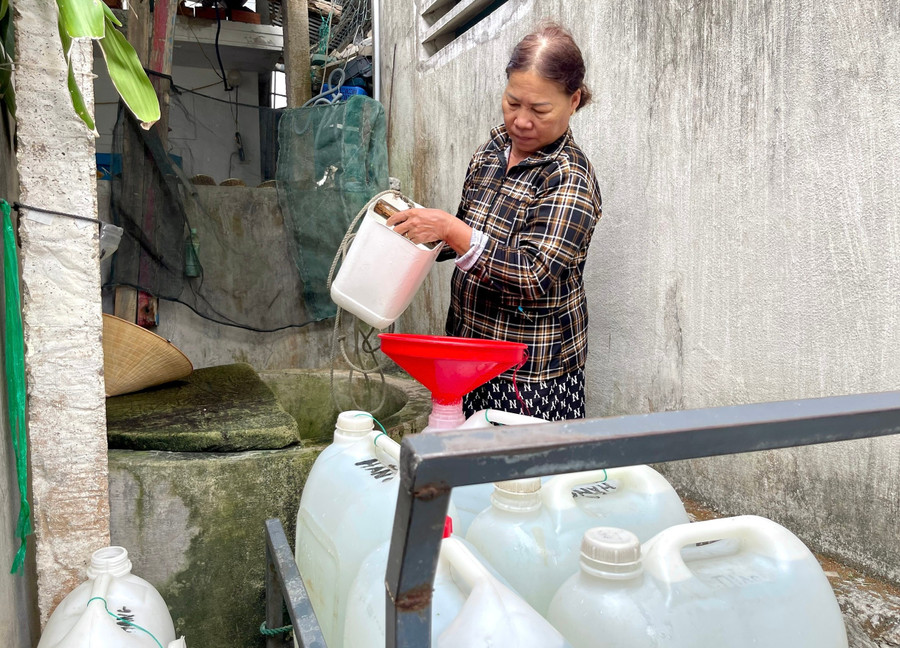 Giữa trưa, bà Trương Thị Hằng mang gàu vét chút nước còn sót lại ở chiếc giếng nước ngọt duy nhất của làng.