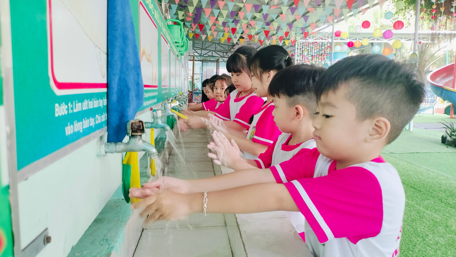 Học sinh Trường Mầm non Nắng Hồng (phường Hòa Thành, Cà Mau) được hướng dẫn rửa tay sau khi đi vệ sinh. Ảnh: QM
