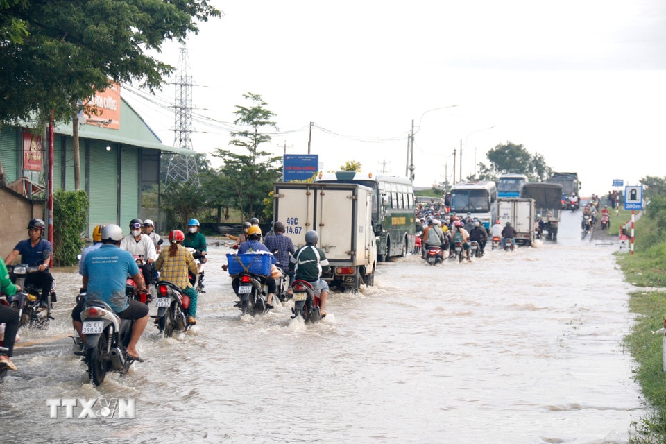Quốc lộ 28 đoạn qua địa bàn phường Hàm Thắng (Lâm Đồng) bị ngập sâu, các phương tiện di chuyển khó khăn. (Ảnh: Nguyễn Thanh/TTXVN)