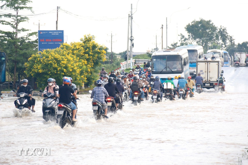 Quốc lộ 28 đoạn qua địa bàn phường Hàm Thắng (Lâm Đồng) bị ngập sâu, các phương tiện di chuyển khó khăn. (Ảnh: Nguyễn Thanh/TTXVN)