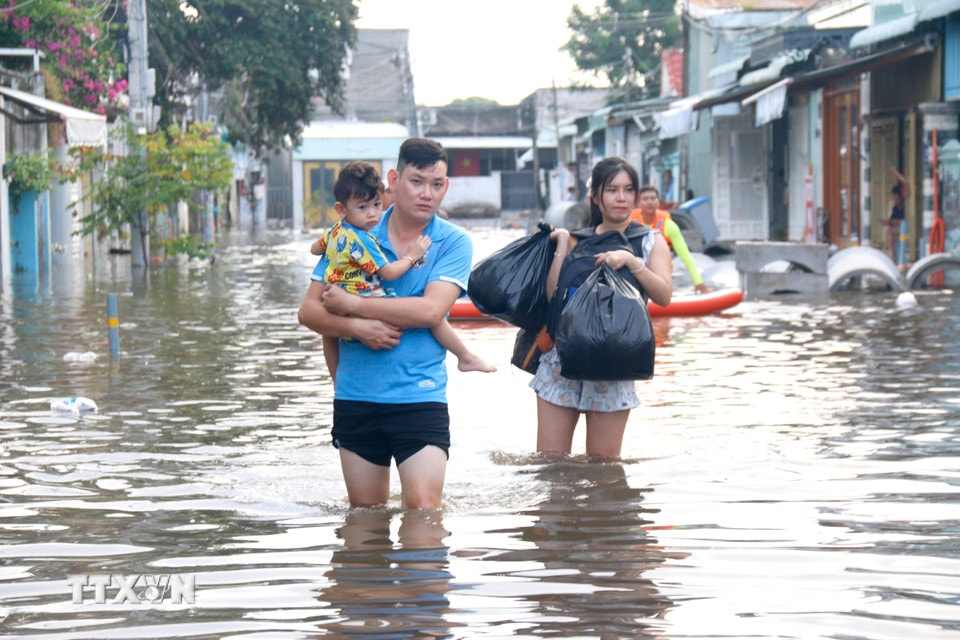 Người dân những khu vực ngập sâu di chuyển đến nơi ở khác. (Ảnh: Nguyễn Thanh/TTXVN)