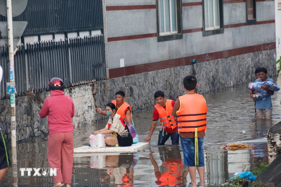 Lực lượng chức năng hỗ trợ người dân những khu vực ngập sâu di dời đến nơi ở khác. (Ảnh: Nguyễn Thanh/TTXVN)