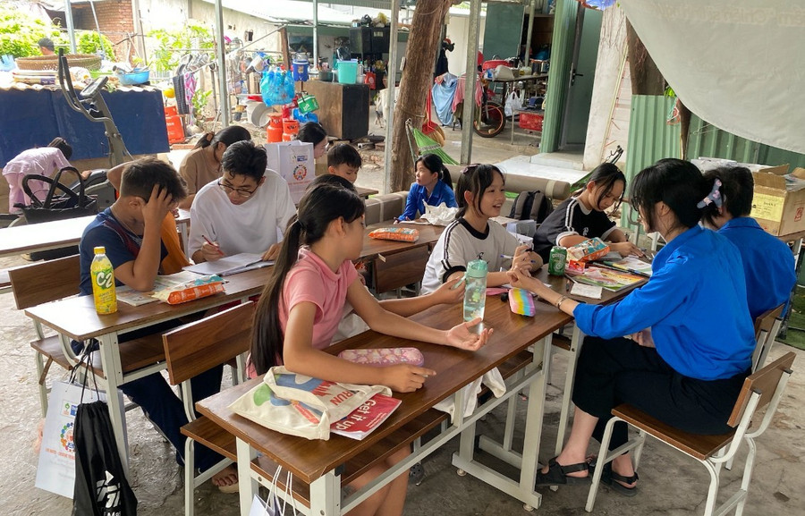 Những bạn trẻ mang áo xanh tình nguyện dạy học cho em nhỏ ở xóm trọ phường Thảo Điền, TPHCM. Ảnh: Phúc Uyên.
