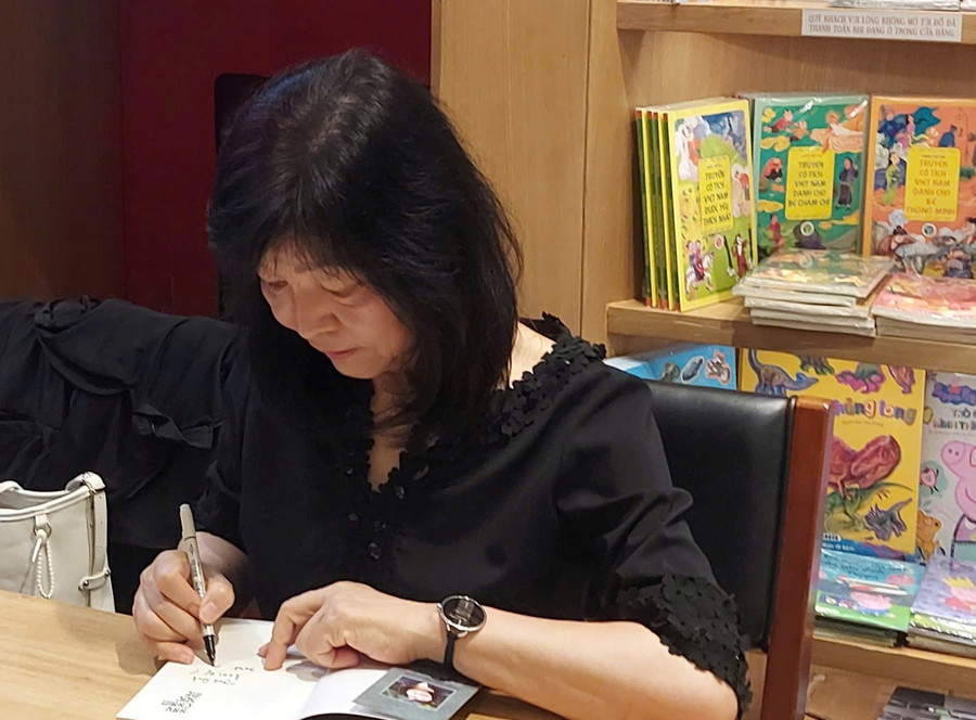 Nhà văn Shin Kyung Sook ký tặng tiểu thuyết 'Hãy chăm sóc mẹ' cho độc giả Việt Nam. Ảnh: Bình Thanh
