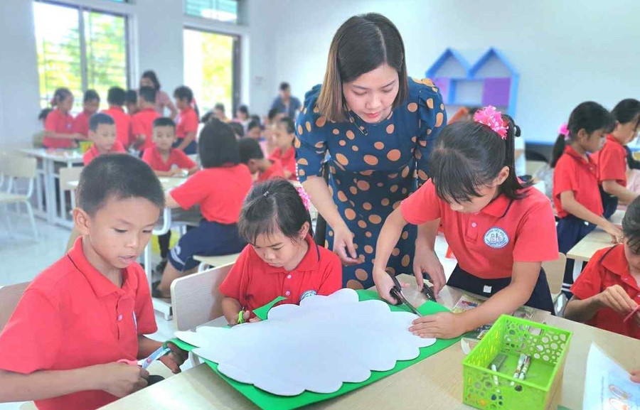 Giáo viên Trường Tiểu học Rạng Đông (Ninh Bình) hướng dẫn học sinh thực hành làm sản phẩm STEM “Cây gia đình”. Ảnh: NTCC