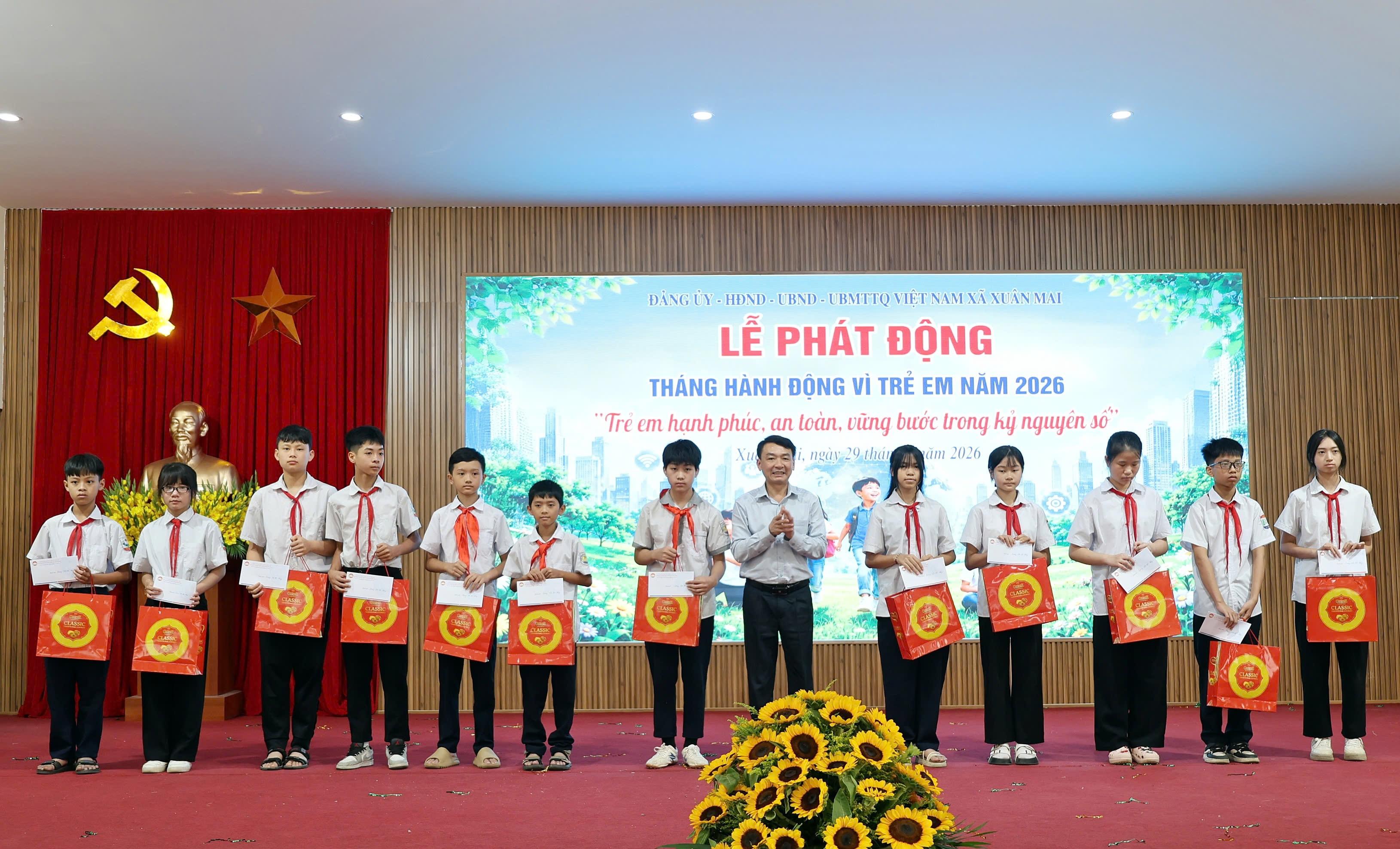 Bí thư Đảng ủy, Chủ tịch HĐND xã Xuân Mai Hoàng Minh Hiến trao quà cho trẻ em có hoàn cảnh khó khăn. Ảnh: PV