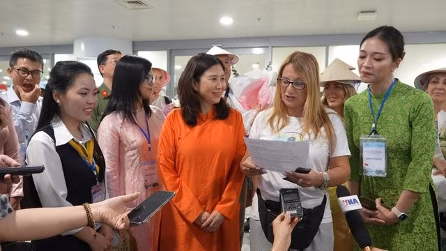 Bà Piñas Piñas Maria Del Mar (mặc áo trắng, đứng giữa) phấn khởi khi được chào đón bằng hoa và quà lưu niệm khi đến Hà Nội. Ảnh: VGP dulich7.jpg
