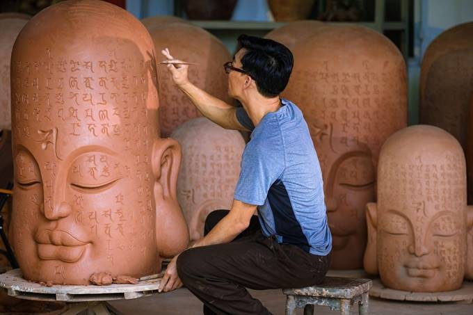 Nghệ sĩ Tuấn Gốm và tác phẩm “Kinh Gốm” được khắc chìm bộ “Chú Đại Bi” 365 chữ. Ảnh: Sun World Ba Den Mountain.