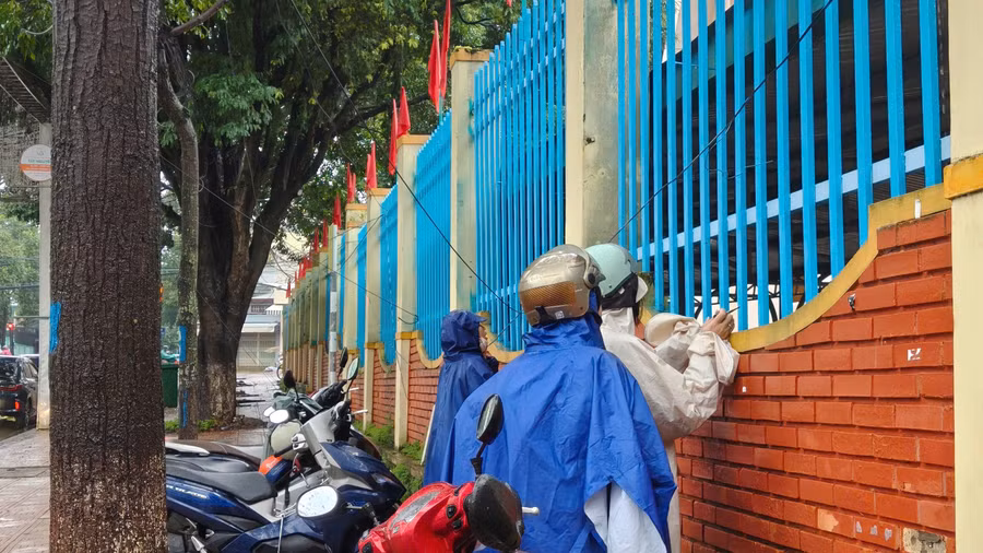 Các giáo viên đội mưa đến cổ vũ, động viên học sinh trước giờ làm bài. 2aobor0jwbfer0dnh3tt9ehtl0yuoqssak3mam3u.jpg