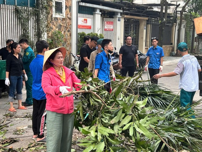 Đồng chí Đào Thị Thu Hằng - Chủ tịch UBND phường Tương Mai (Hà Nội) cùng nhân dân dọn dẹp đường phố sau siêu bão Yagi, tháng 9-2024